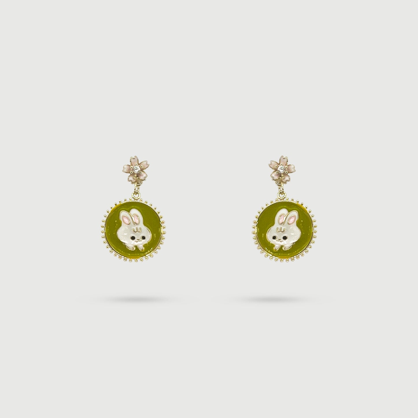 Boucles d'oreilles lapin blanc dans un miroir vert avec cerisier