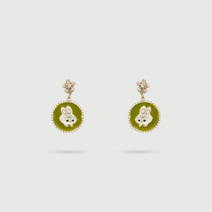 Boucles d'oreilles lapin blanc dans un miroir vert avec cerisier