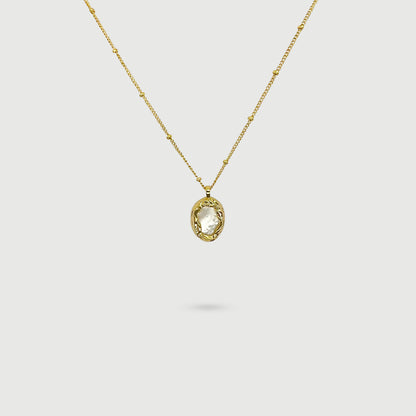 Collier coquille de perle ovale entourée de tissages dorés